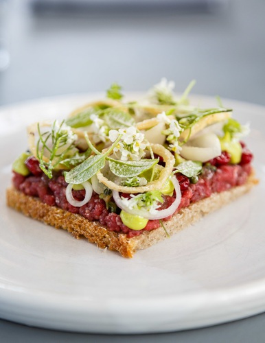 Smorrebrod or an open sandwich of tartar of beef with onion, lingoberries & sorrel at Almanak Restaurant, Copenhagen, Denmark.. Almanak, Denmark, Europe,