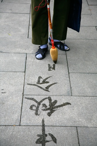 Man writing calligraphy on the ground with water brush at Beihai Park, Beijing, China.. Asia, China, Chinese, East, Far, Peking, asian, beihai, brush,. China, Beijing