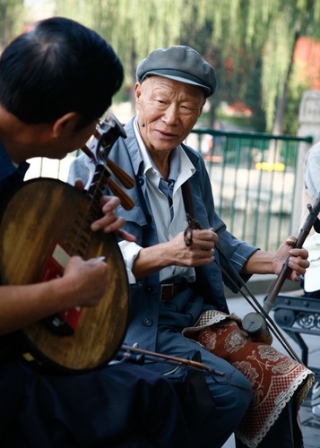 Musician playing traditional instruments at the Beihai lake, Beijing, China.. Asia, China, Chinese, East, Far, Peking, asian, city, erhu, fiddle, instrument,. China, Beijing